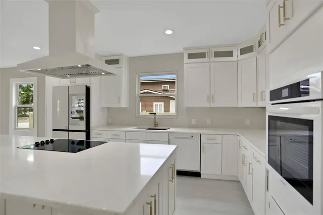 a kitchen with stainless steel appliances granite countertop a sink and white cabinets