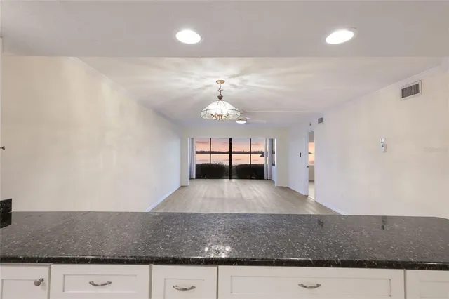 a view of a big room with wooden floor cabinet and windows