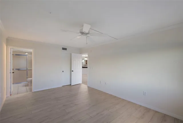 a front view of a building with garden and trees