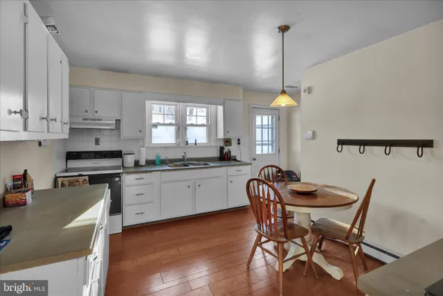 a kitchen with a dining table chairs and cabinets