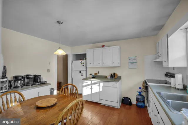 a kitchen with stainless steel appliances granite countertop a sink a stove a refrigerator cabinets and living room view