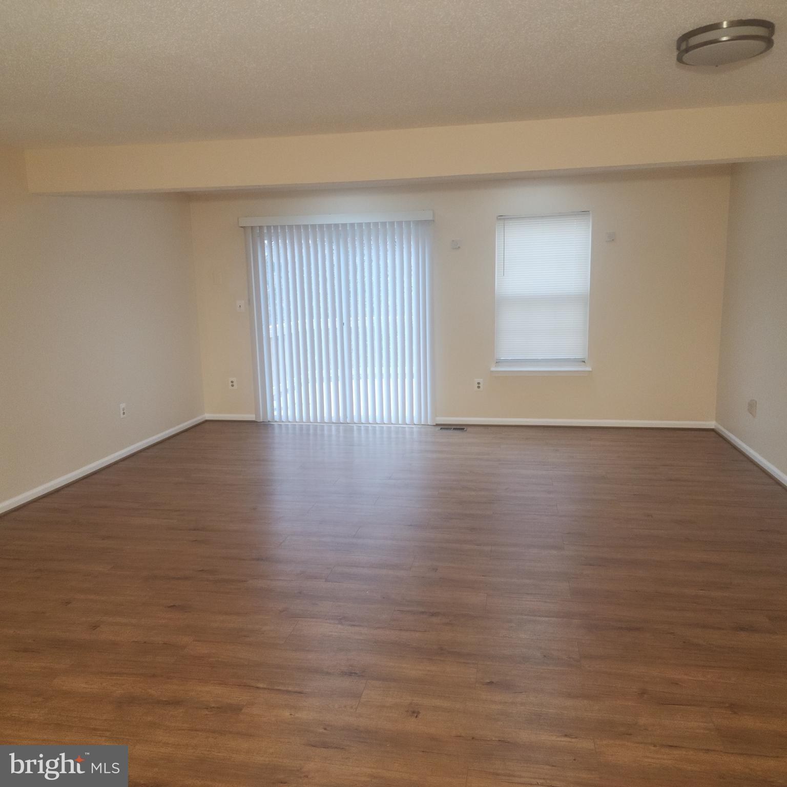 7438 Catterick Court Baltimore, MD 21244 - Photo 7 of 27 a view of an empty room with wooden floor and a window
