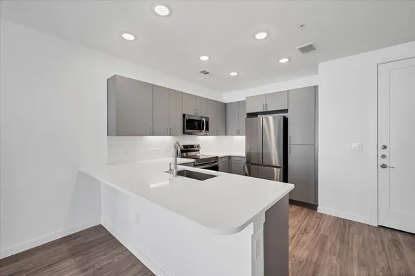 a kitchen with refrigerator cabinets and wooden floor