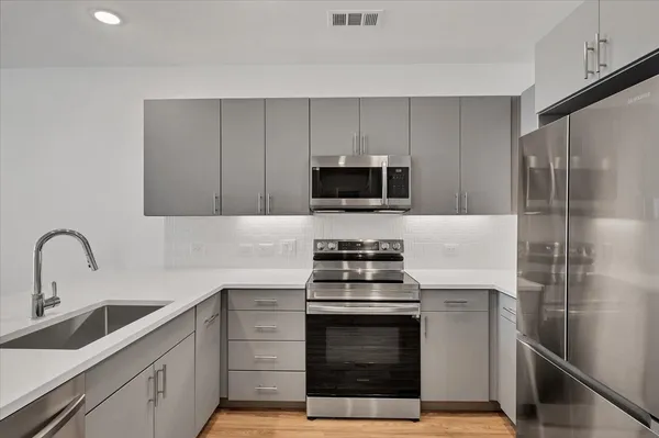 a kitchen with a sink stove and refrigerator