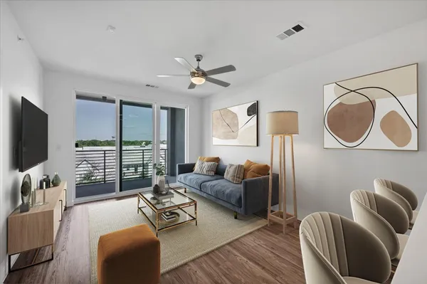 a living room with furniture ceiling fan and a flat screen tv