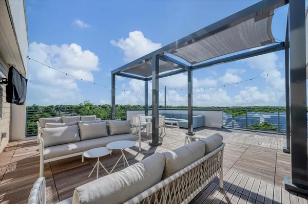a roof deck with couches and potted plants