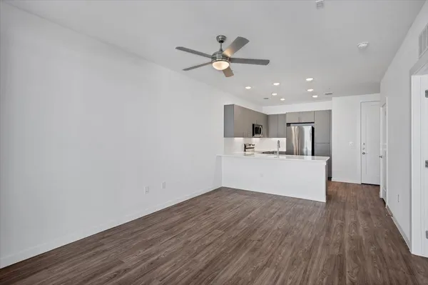 a view of a kitchen with wooden floor and a ceiling fan