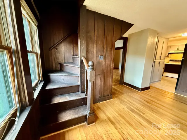 a view of a hallway with wooden floor and staircase
