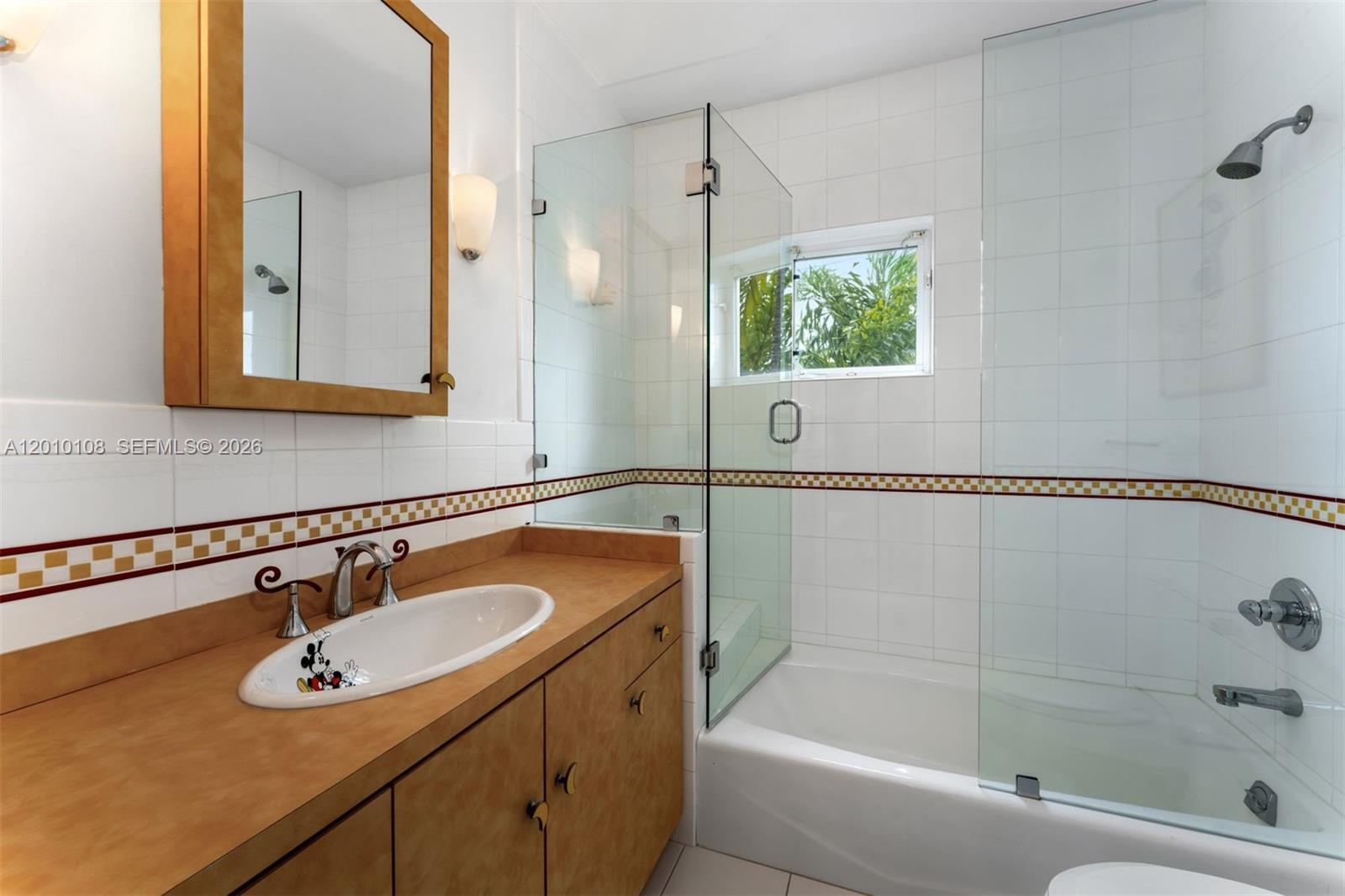 690 Warren Lane Key Biscayne, FL 33149 - Photo 26 of 39 a bathroom with a granite countertop sink a mirror a bathtub and shower