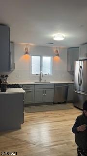 111 Pennington Street Newark, NJ 07105 - Photo 5 of 13 a kitchen with stainless steel appliances a sink cabinets and wooden floor