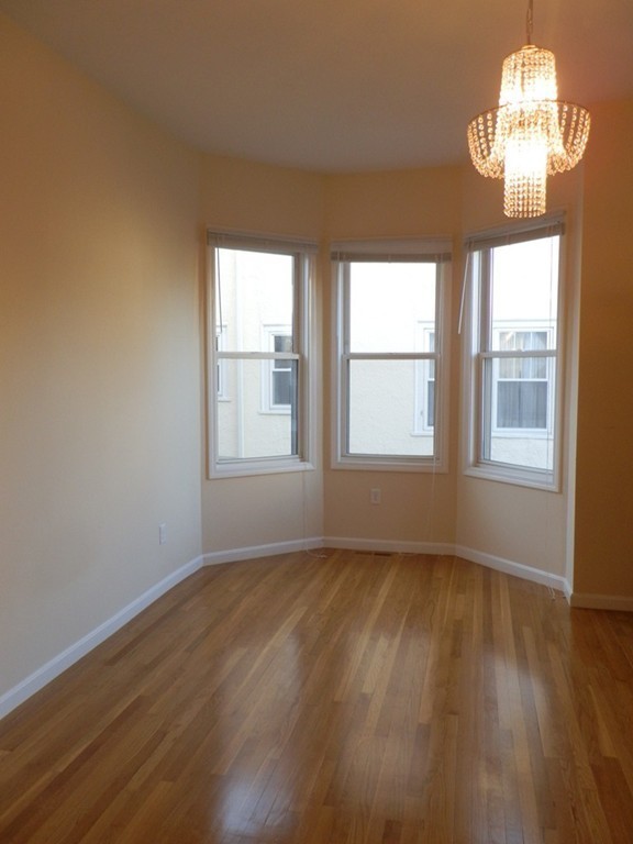 194 Auburn Street, Unit 1 Newton, MA 02466 - Photo 11 of 15 a view of an empty room with wooden floor and a window