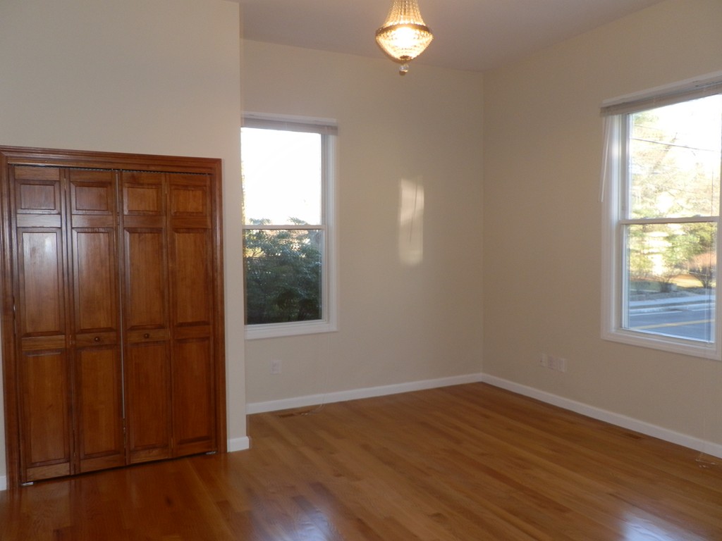 194 Auburn Street, Unit 1 Newton, MA 02466 - Photo 2 of 15 an empty room with wooden floor closet and windows