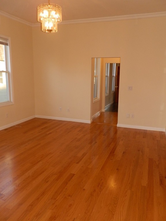 194 Auburn Street, Unit 1 Newton, MA 02466 - Photo 3 of 15 a view of an empty room with wooden floor and a window