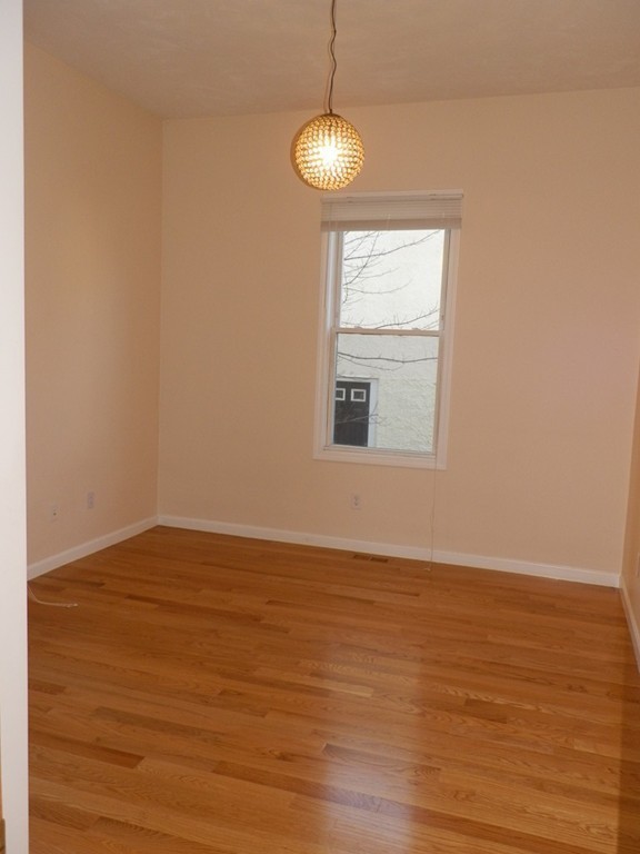 194 Auburn Street, Unit 1 Newton, MA 02466 - Photo 10 of 15 a view of an empty room with wooden floor and a window