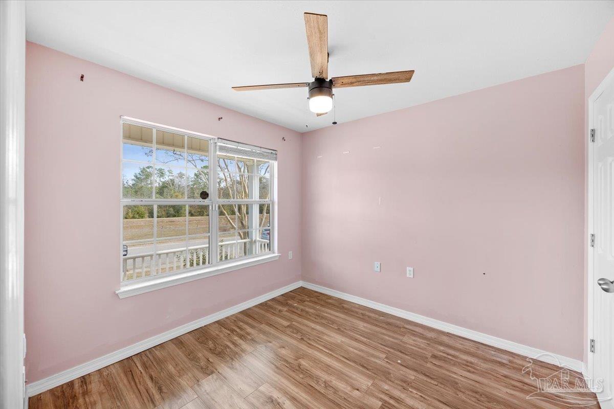 1186 Brownfield Road Pensacola, FL 32526 - Photo 11 of 20 a view of an empty room with a window and wooden floor