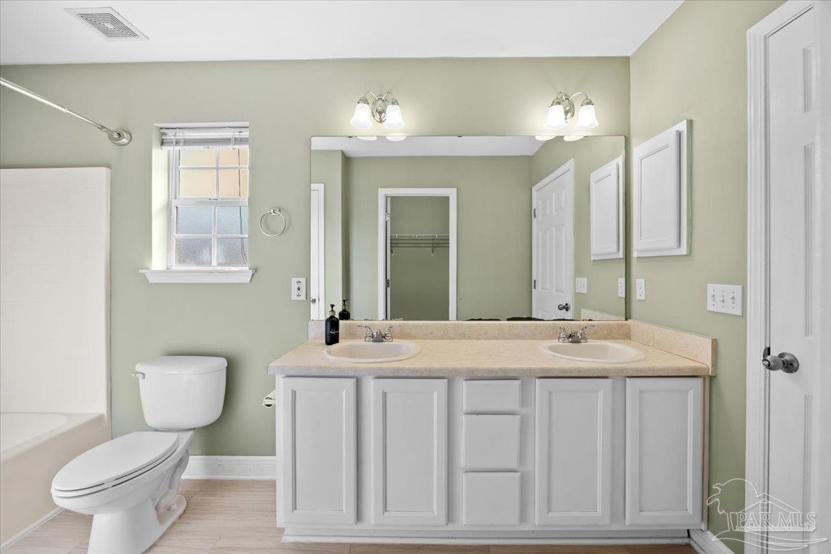 1186 Brownfield Road Pensacola, FL 32526 - Photo 15 of 20 a bathroom with a granite countertop toilet a sink and a mirror