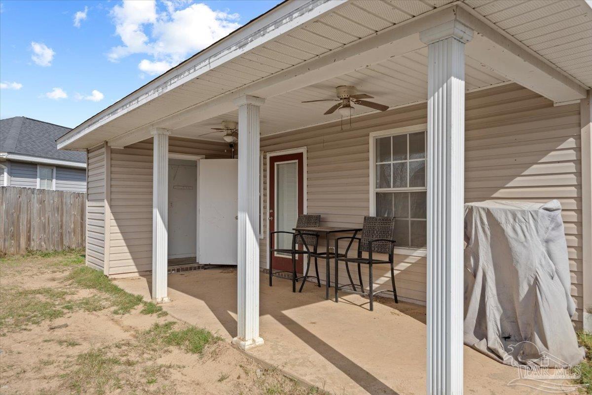 1186 Brownfield Road Pensacola, FL 32526 - Photo 18 of 20 a view of a patio with table and chairs with wooden floor and fence