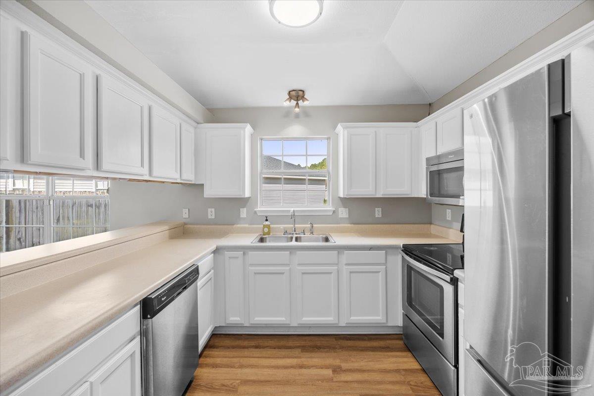 1186 Brownfield Road Pensacola, FL 32526 - Photo 8 of 20 a kitchen with a sink stove and cabinets