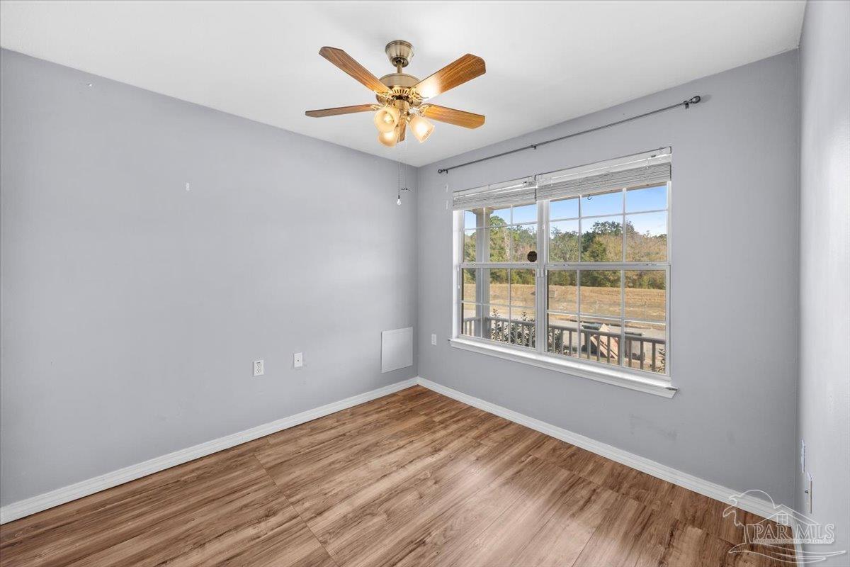 1186 Brownfield Road Pensacola, FL 32526 - Photo 10 of 20 an empty room with wooden floor and windows