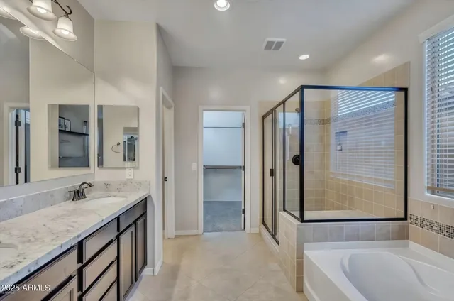 a bathroom with a granite countertop sink mirror and a bathtub