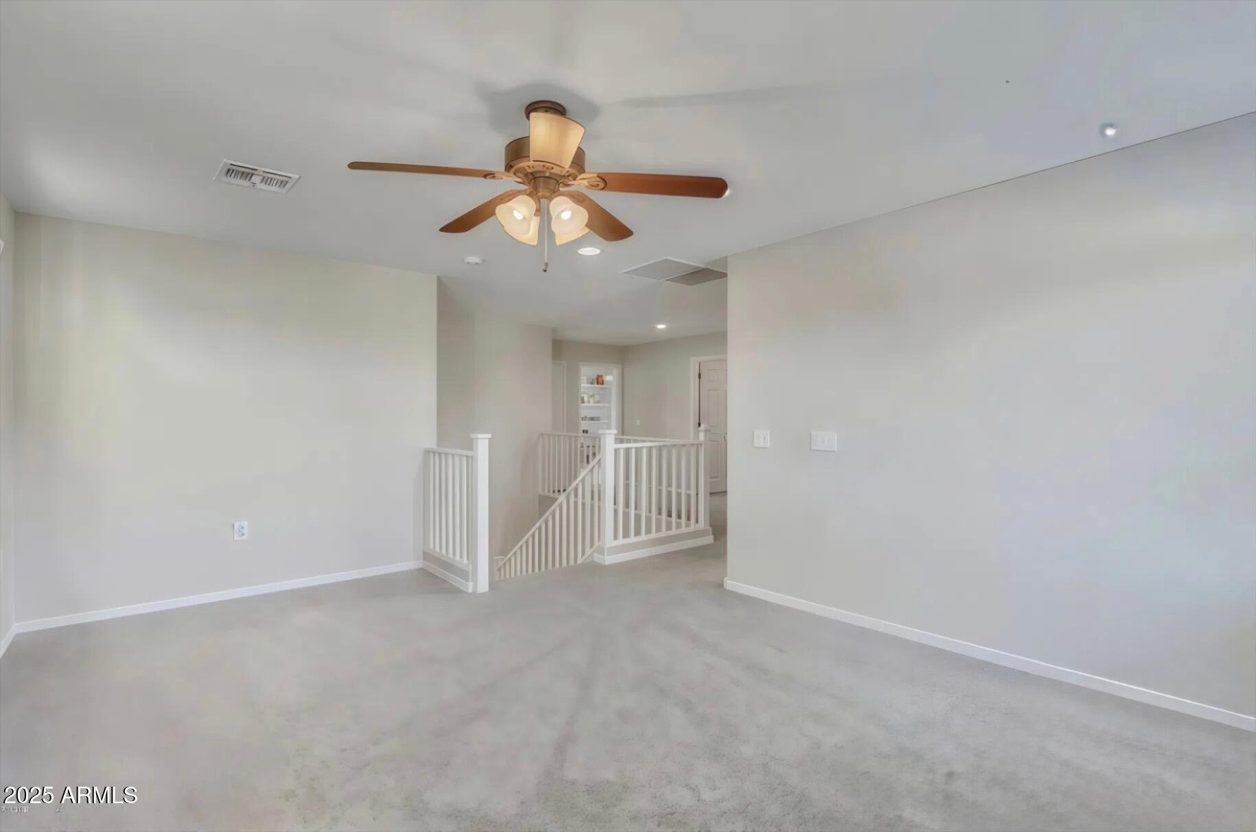 7538 West Redbird Road Peoria, AZ 85383 - Photo 12 of 24 an empty room with chandelier fan and windows