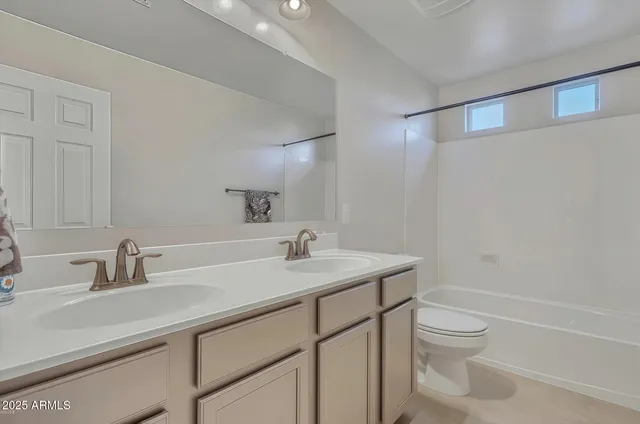 a bathroom with a sink toilet vanity and shower