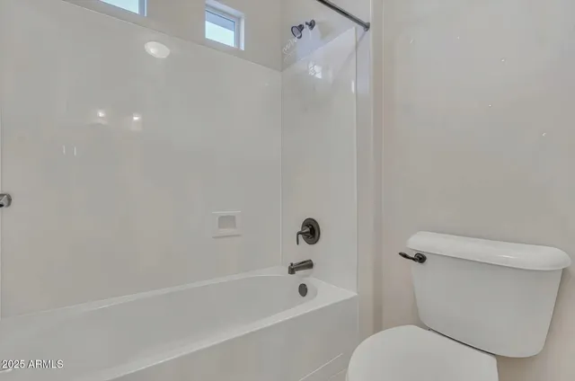 a white toilet sitting next to a bath tub