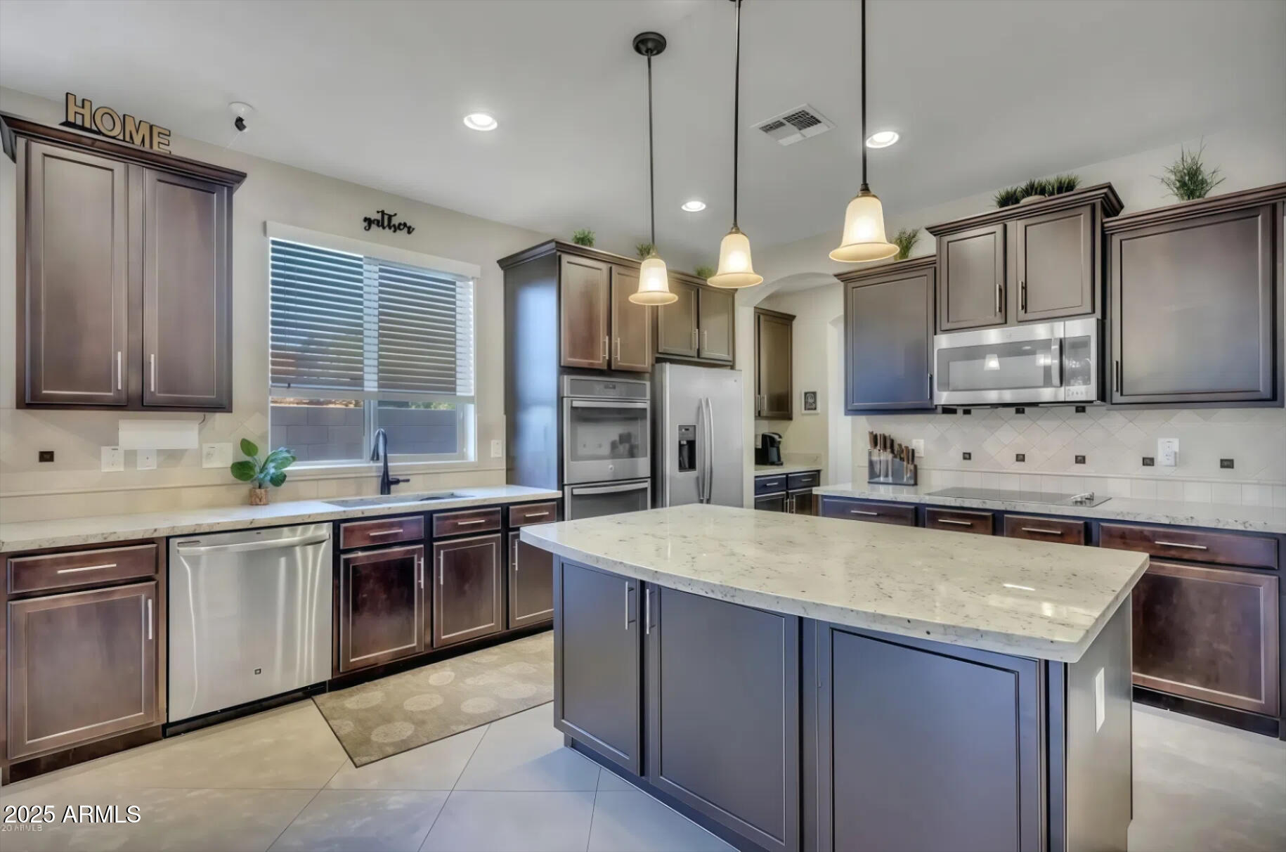7538 West Redbird Road Peoria, AZ 85383 - Photo 4 of 24 a large kitchen with stainless steel appliances granite countertop a sink stove and refrigerator