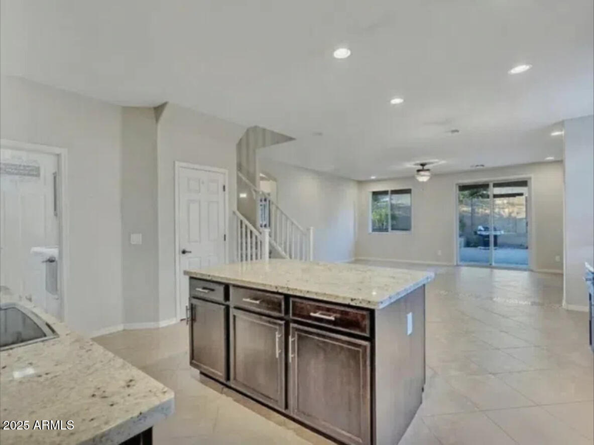 7538 West Redbird Road Peoria, AZ 85383 - Photo 5 of 24 a kitchen with stainless steel appliances granite countertop a sink and a stove