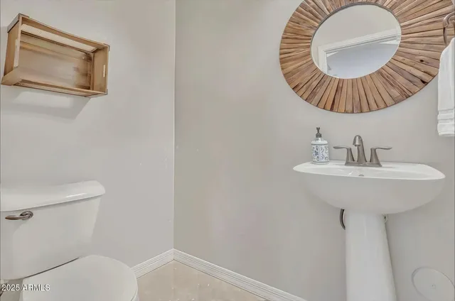 a bathroom with a sink a toilet and mirror