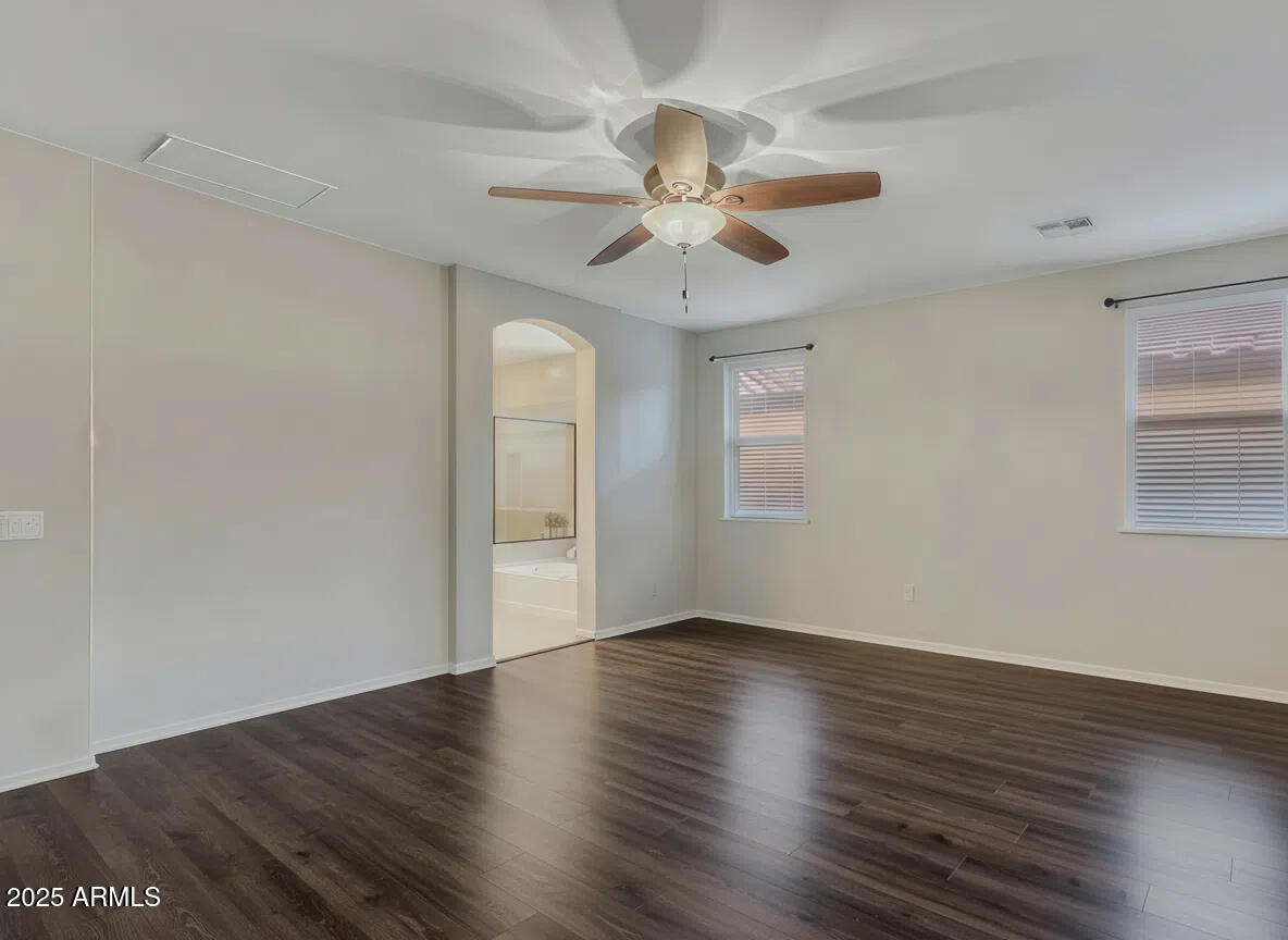 7538 West Redbird Road Peoria, AZ 85383 - Photo 9 of 24 a view of an empty room with wooden floor and a window