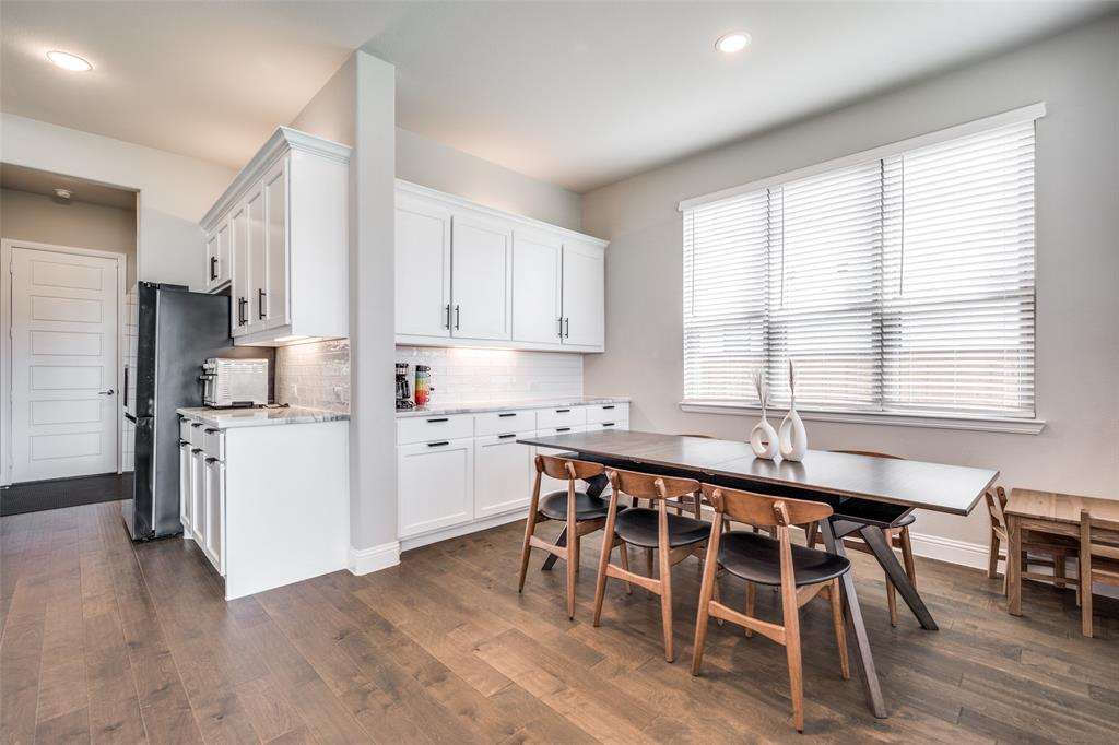 16564 Creek Plum Road Frisco, TX 75033 - Photo 10 of 30 Kitchen with white cabinetry, decorative backsplash, dark wood-type flooring, recessed lighting, and freestanding refrigerator