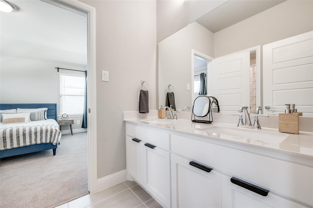 16564 Creek Plum Road Frisco, TX 75033 - Photo 21 of 30 Ensuite bathroom with double vanity, light tile patterned floors, light colored carpet, and curtained shower