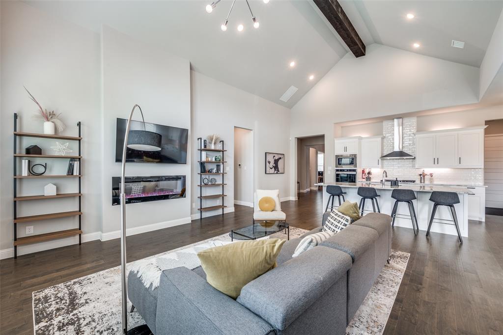 16564 Creek Plum Road Frisco, TX 75033 - Photo 6 of 30 Living room with dark wood-type flooring, hanging lights, and a glass covered fireplace