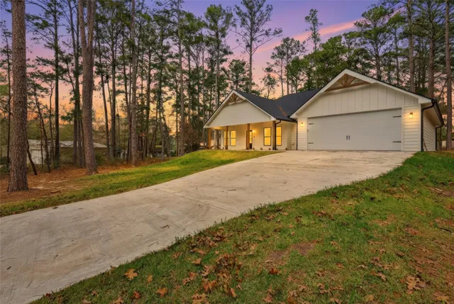 a front view of a house with a yard and trees