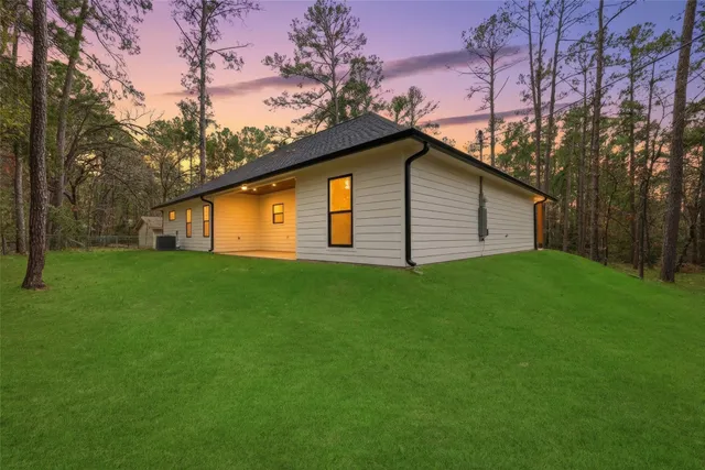 an aerial view of a house with a yard and large trees