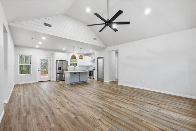 a view of a livingroom with a ceiling fan and wooden floor
