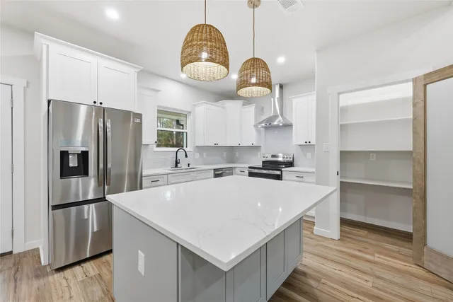a kitchen with stainless steel appliances granite countertop a stove a sink and a refrigerator