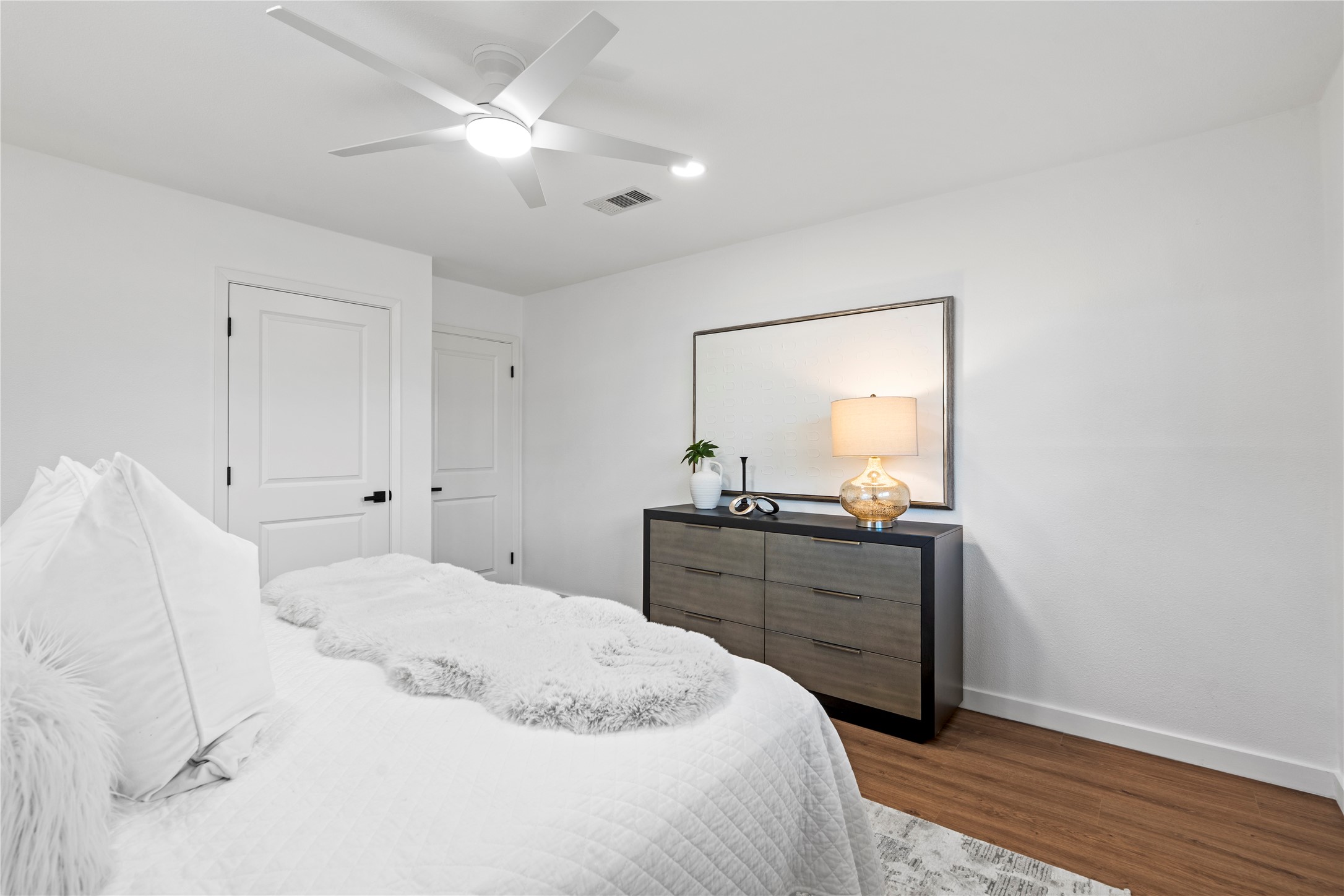 5023 Redstart Street Houston, TX 77035 - Photo 25 of 34 The primary bedroom features a clean, neutral palette and a contemporary ceiling fan, creating a comfortable and sophisticated private haven.