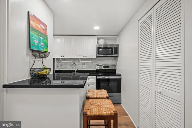 a kitchen with stainless steel appliances a sink stove and cabinets