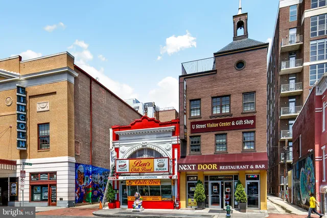 a front view of multi story building with retail shops