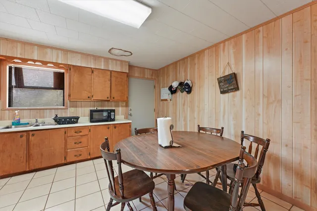 a kitchen with stainless steel appliances granite countertop a kitchen island a table and chairs in it