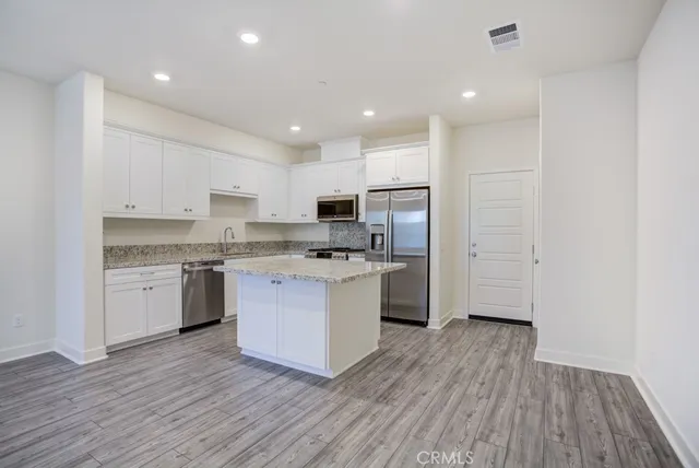 a large kitchen with stainless steel appliances granite countertop a stove and a sink