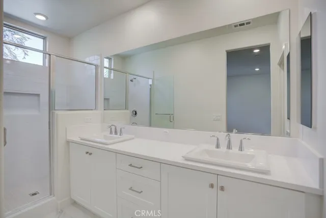 a spacious bathroom with double vanity and mirrors