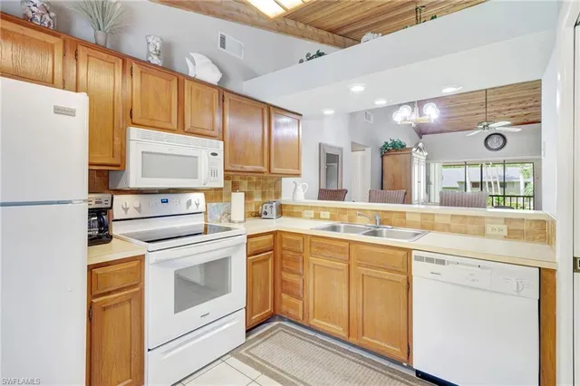 a kitchen with stainless steel appliances granite countertop a refrigerator sink and white cabinets