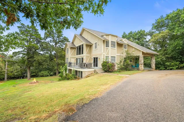 a view of a house with a yard and large tree