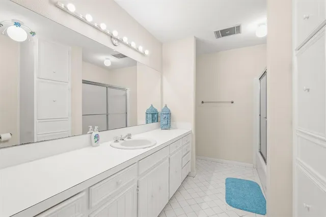 a spacious bathroom with a sink a mirror and a shower