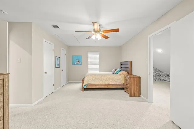 a spacious bedroom with a bed and ceiling fan