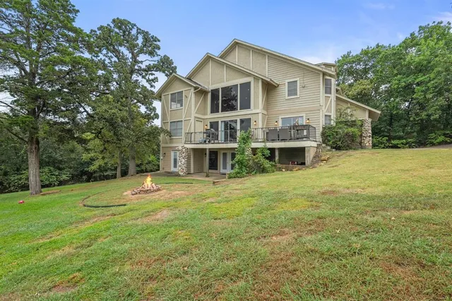 a front view of a house with a garden and trees