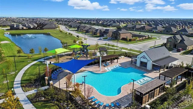 an aerial view of a house with swimming pool and outdoor seating